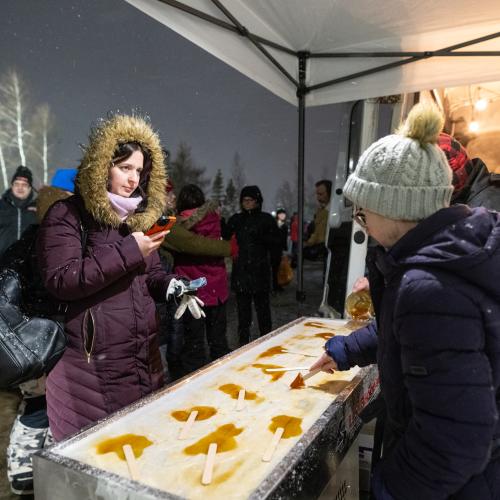 People getting maple taffy on the snow