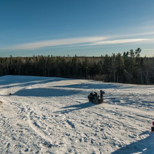 People sliding down a snowy hill