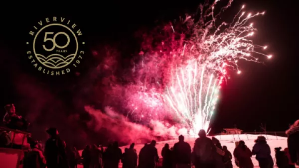 Crowd of people watching fireworks glowing red in the wintertime