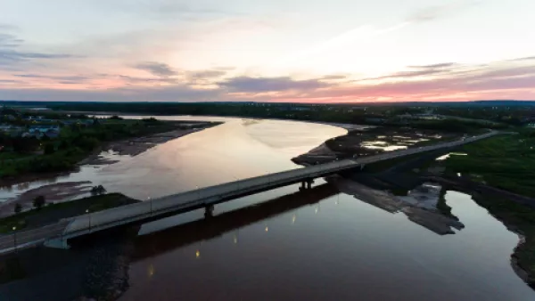 Aerial view of a bridge spanning a river at dusk