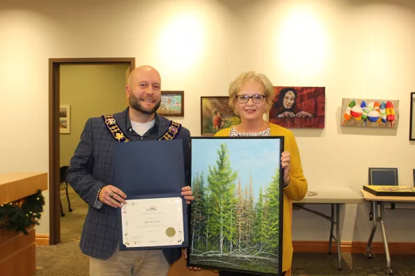 Artist holding tree painting with mayor