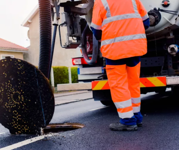 Construction worker cleaning sewer