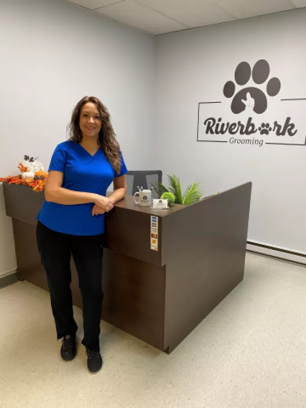 Owner of Riverbark grooming standing by counter