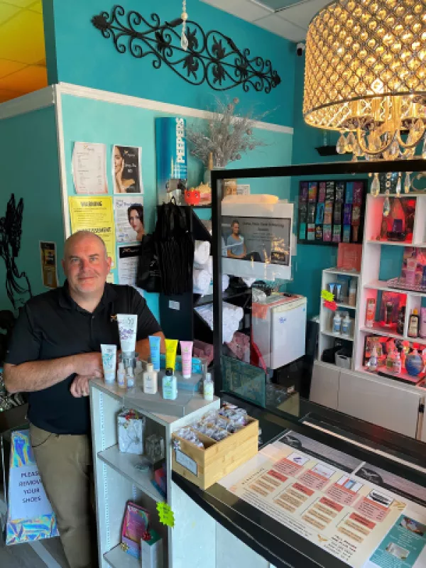 Owner standing by checkout counter at salon