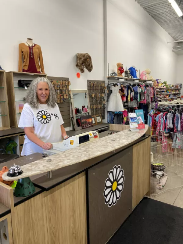 Owner of Dayzee's thrift store standing behind counter