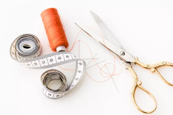 Sewing scissors, thread, and a flexible measuring tape 