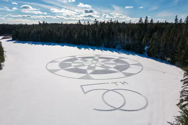 a 50th symbol imprinted on snow over a frozen lake