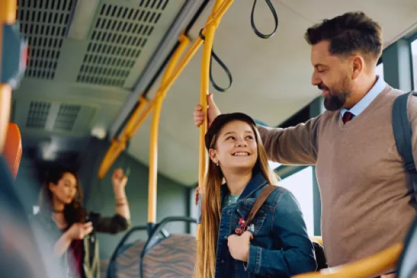 a young girl riding the bus with her family 