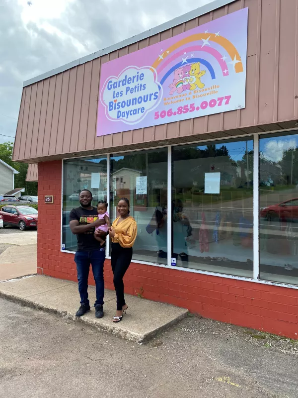 Business owners standing outside building with child