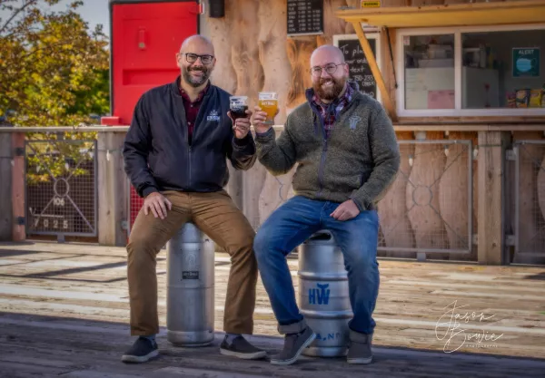 Pete and Jeff Grandy cheers a beer on the patio of Holy Whale Beer Hall