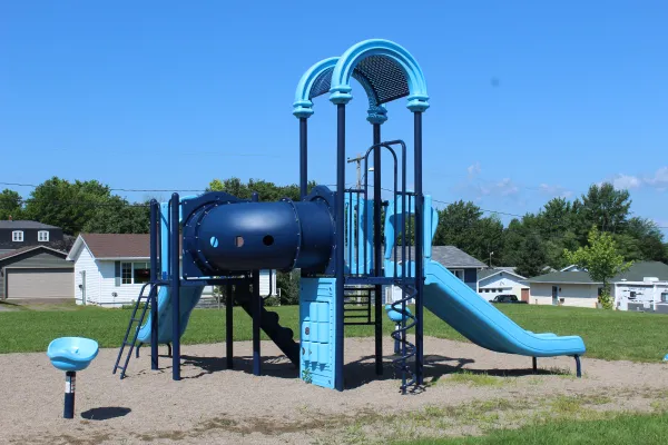 A playground in the Byron Court neighbourhood surrounded by houses and blue clear skies.