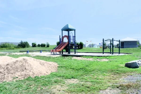 A playground around sand with blue clear sky in the background next to the Coverdale Centre