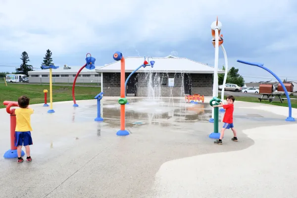A splash pad with children playing next to the Coverdale Centre 