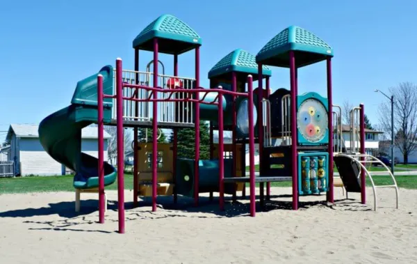 A playground with sand and a blue clear sky in the background 