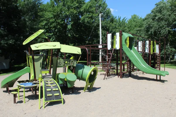 Two playground structures surrounded by trees on Ridgeway Drive