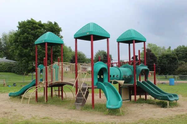 A playground with cloudy blue sky in the background on Wentworth Drive.