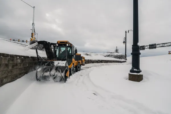 Snow plow clears snow off sidewalk by gunningsville bridge