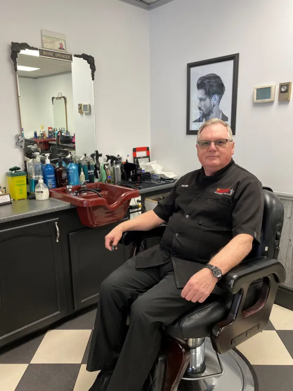 Wayne sitting in one of the barber's chairs