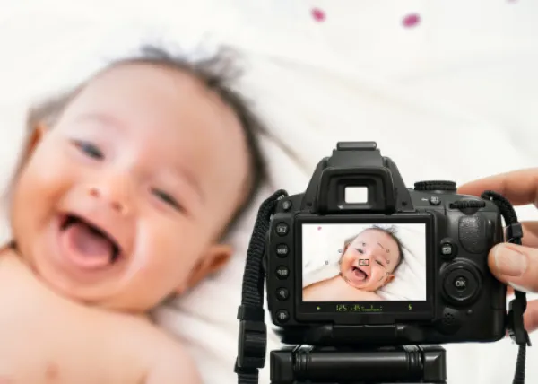 baby laughing, camera showing a preview of the photo taken of the baby