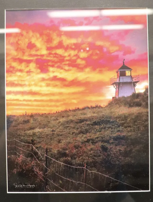 Photograph of a fiery sky and a lighthouse landscape. 