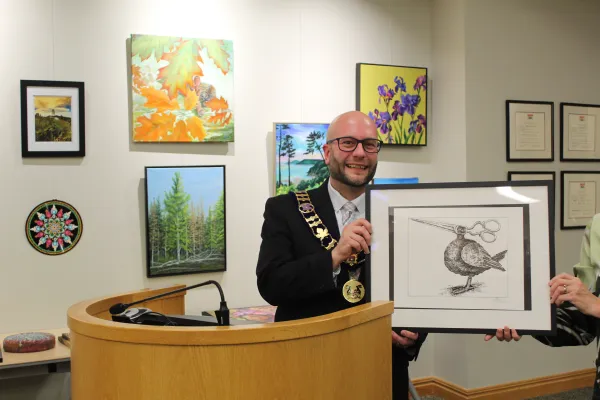 Mayor holding artwork and smiling