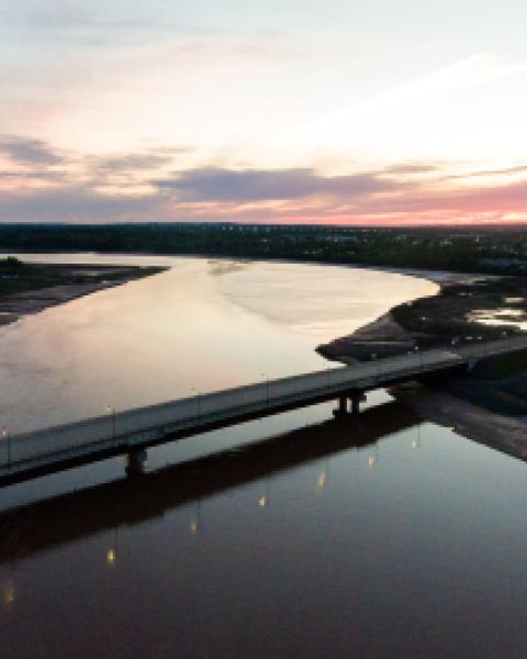 Aerial view of a bridge spanning a river at dusk