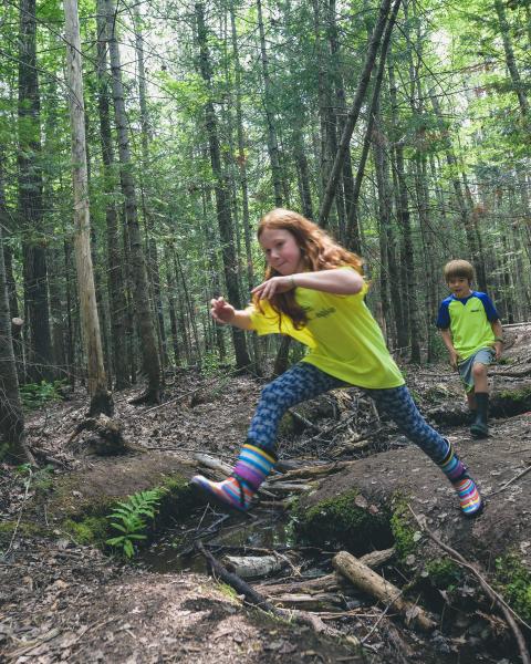 Youth running and playing in the woods