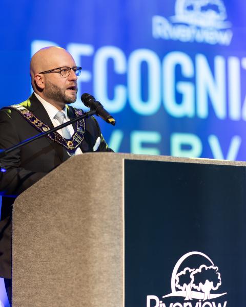 The mayor standing at a podium speaking