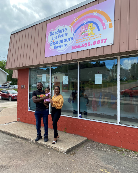 Business owners standing outside building with child