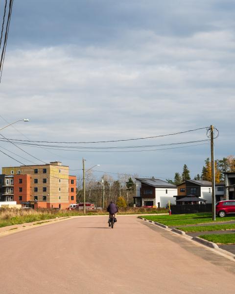 man bikes down street alongside semi detached houses