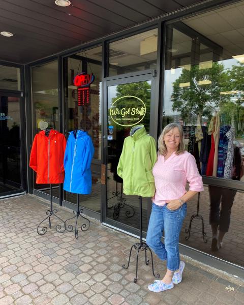 Store owner standing outside storefront smiling 